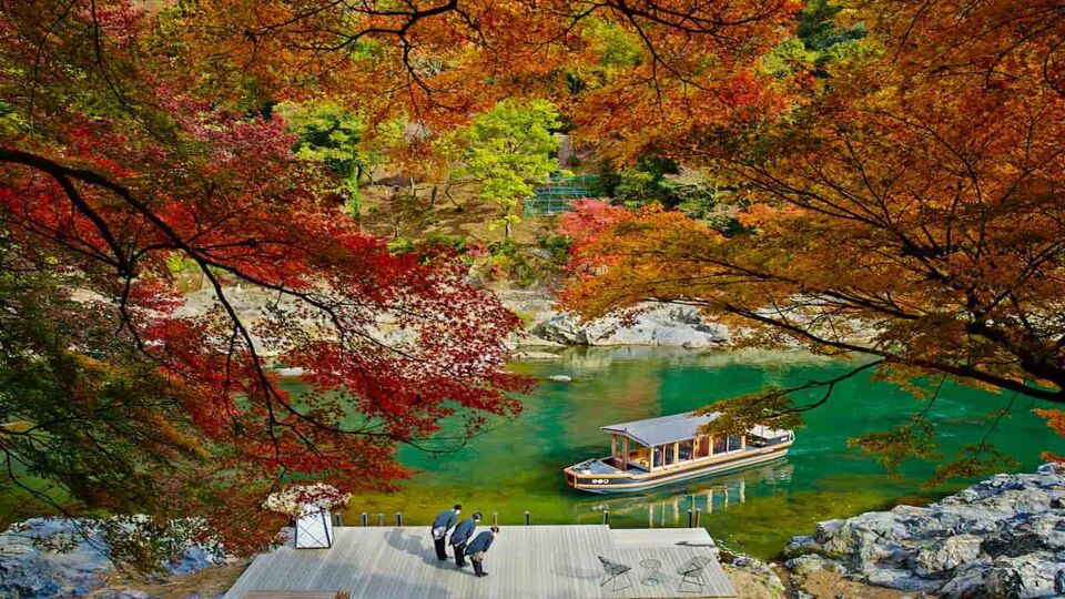Autumn leaves and boat in shallow river