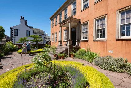 Visitors in the garden in June at Wordsworth House, Cumbria, the birthplace and childhood home of romantic poet William Wordsworth and his sister Dorothy.