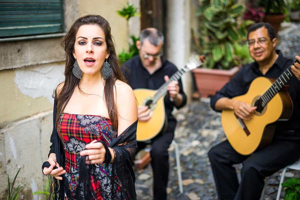 Woman fado sining with guitarists behind