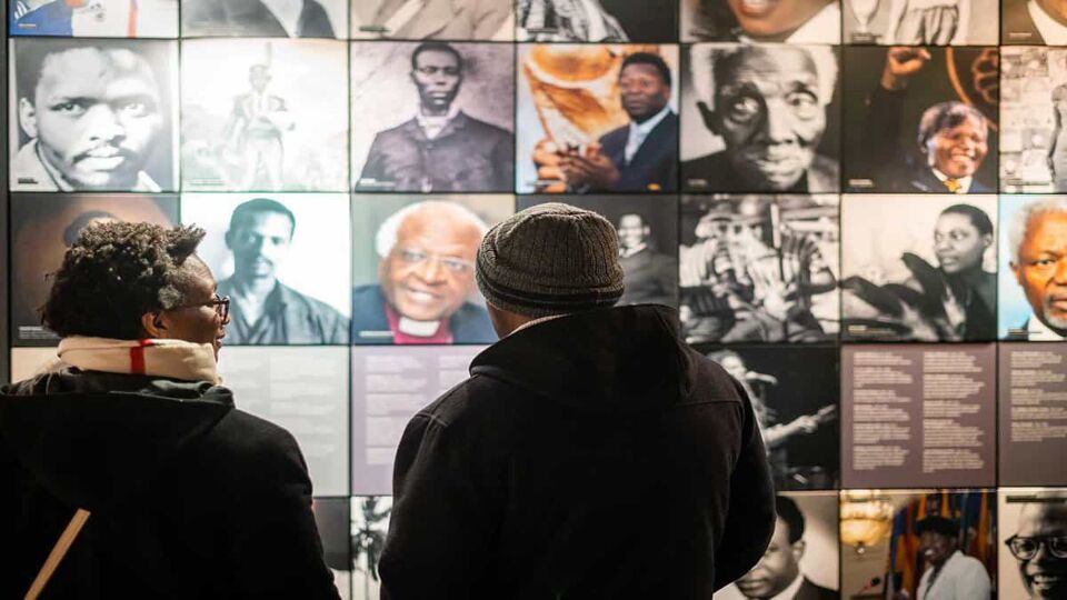 Visitors looking at photos on the wall on famous faces