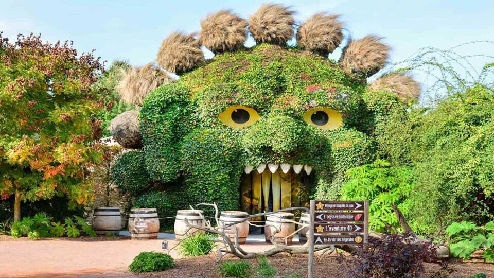 Flowers and bushes shaped into a face at the entrance to the park