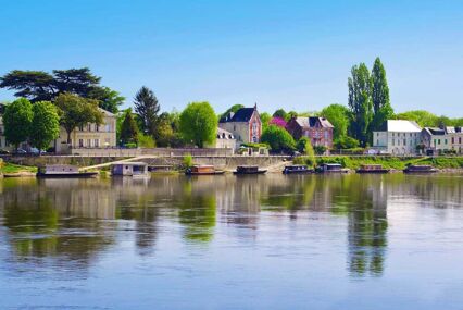 landscape of small buildings in Saumur alongside the river bank
