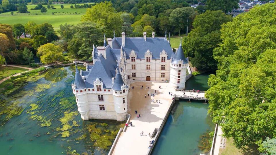 Aerial view from above showing the beautiful turreted chateau surrounded by lake and river