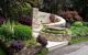 Close up of a stone circular seating area surrounded by shrubs