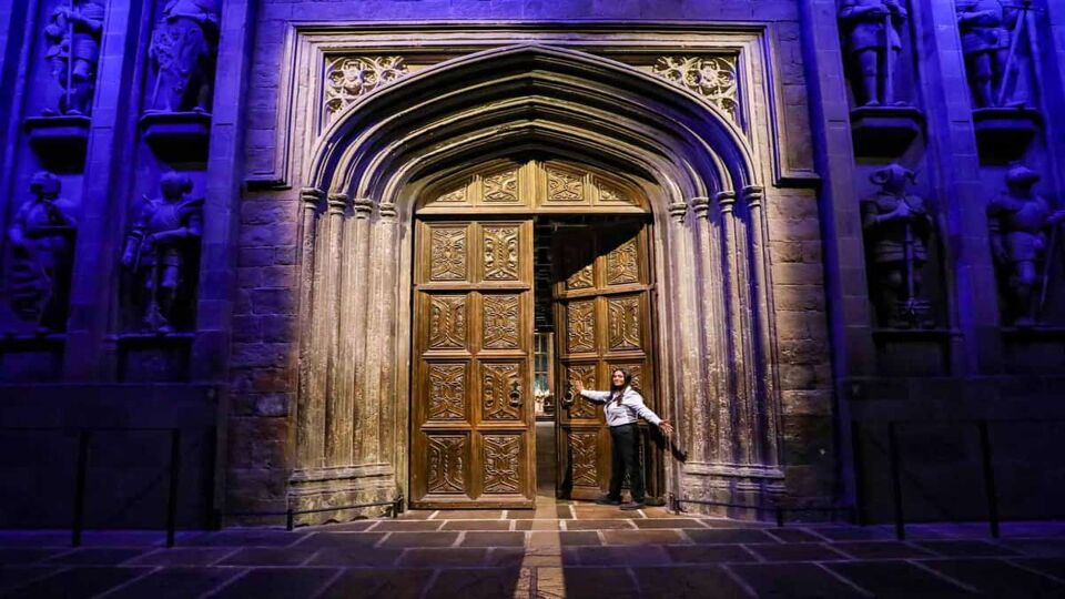 A woman opening a door that was used in the Harry Potter franchise
