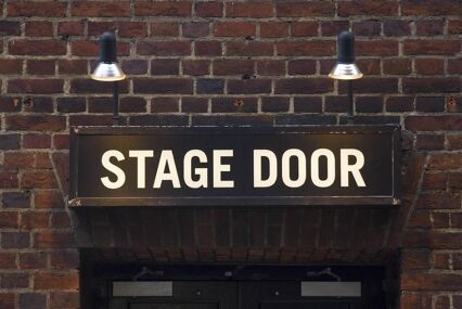 Close up of a stage door sign outside of a theatre
