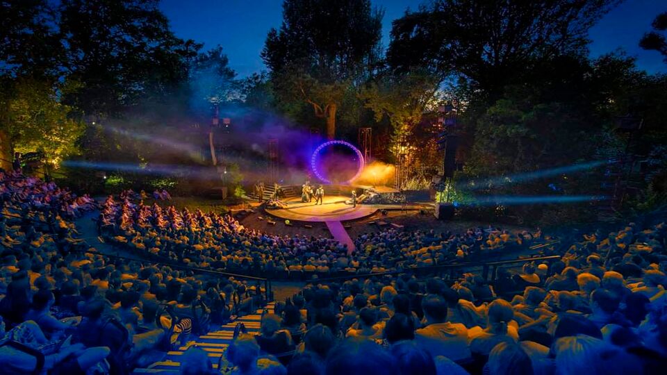 A full crowd viewing a show in the twilight hours