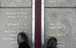 A person standing on the prime meridian line