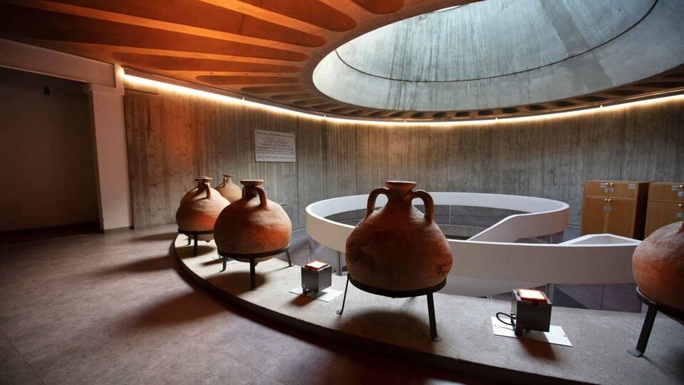 Several Roman pots arranged around a curved room