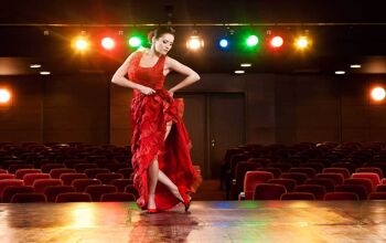 Sexy flamenco dancer performing her dance in a red long dress.