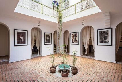 Tiled interior courtyard of a riad (traditional Moroccan home) with plants and a fountain