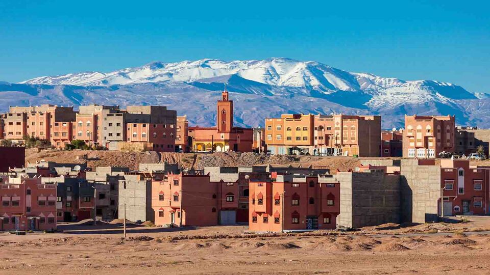 Desert town with snow-capped mountains in the background