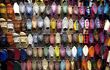 Shop display of colourful leather slippers lining a wall