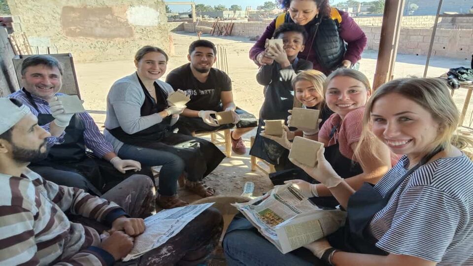 group of young people showing the tiles they have made