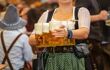 Woman in traditional dress carrying tray of beer