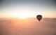 hot air balloon travelling into the sunset in the Sossusvlei Desert