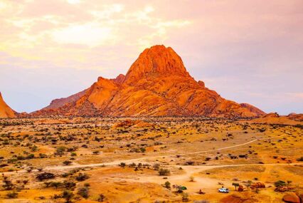 Spitzkoppe Mountain in an orange and yellow light, the mountain glowing red