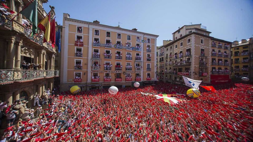 People celebrate during the launch of the 'Chupinazo' rocket, to celebrate the official opening of the 2016 San Fermin Fiestas, in Pamplona, Spain,