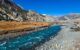 Yaks gazing in the Manang Valley, Annapurna Circuit Trek, Himalayas, Nepal. Dry landscape. Small stream of water. High altitude mountains around the valley. Beautiful and serene landscape.