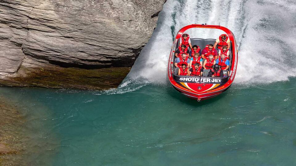 Tourists enjoy a high-speed boat ride on Shotover river near Queenstown. Queenstown is a recognized center of extreme entertainment. South Island
