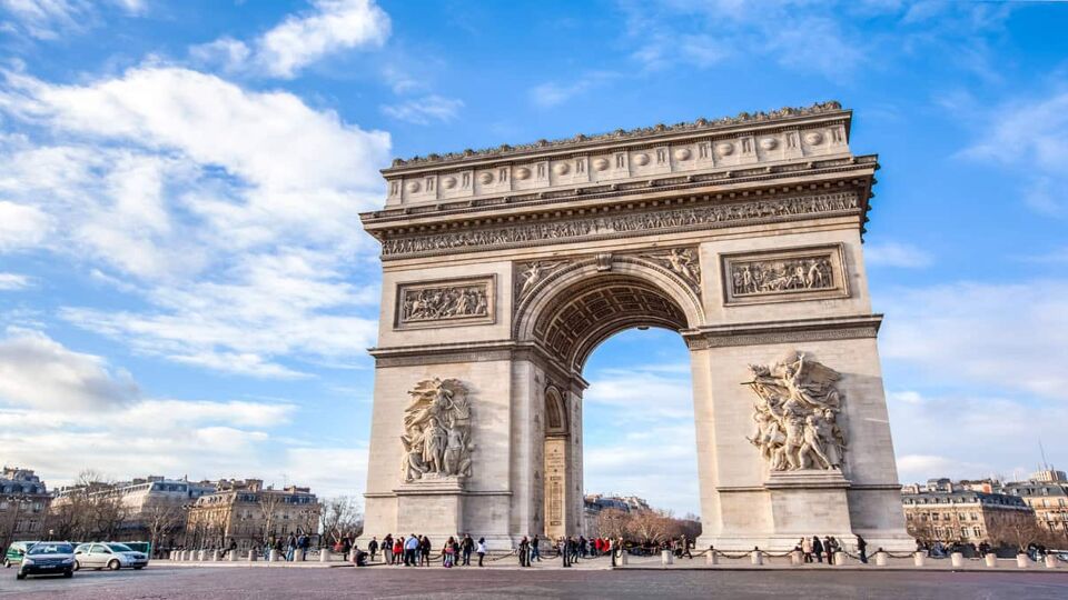 Landscape view of Arc de Triomphe on a cloudy blue day