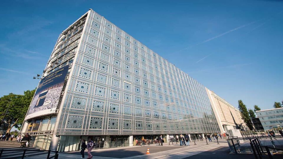 Outside view of Institut du Monde Arabe where the smooth white and grey square appearance, plays with the transparency of the structure.