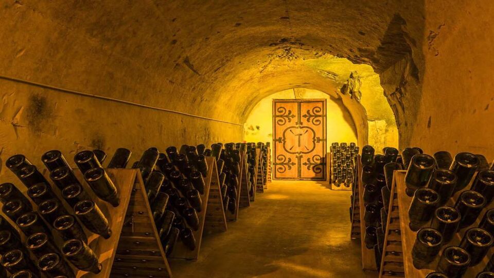 The caves of Champagne House Mumm with old bottles Champagne in pupitres and door of old monastery