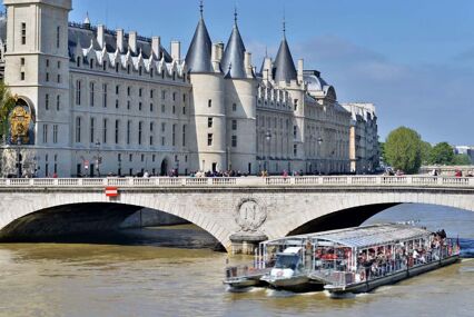Boat coming out from under bridge in front of La Conciergerie