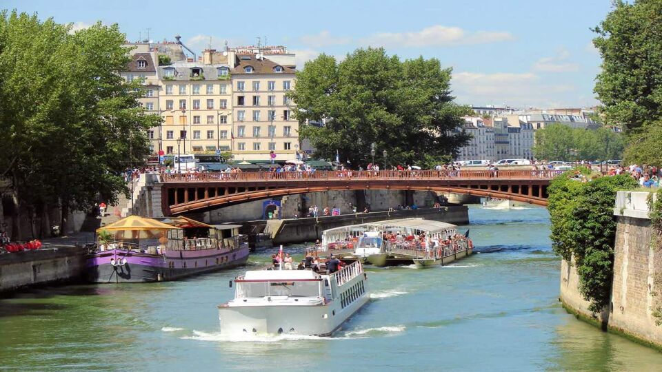 two tourist boats passing under a bridge on River Seine