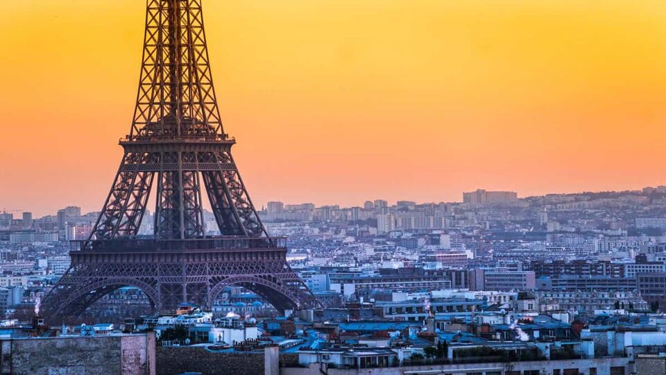 Aerial view of the Eiffel Tower and the city of Paris during an orange sunset