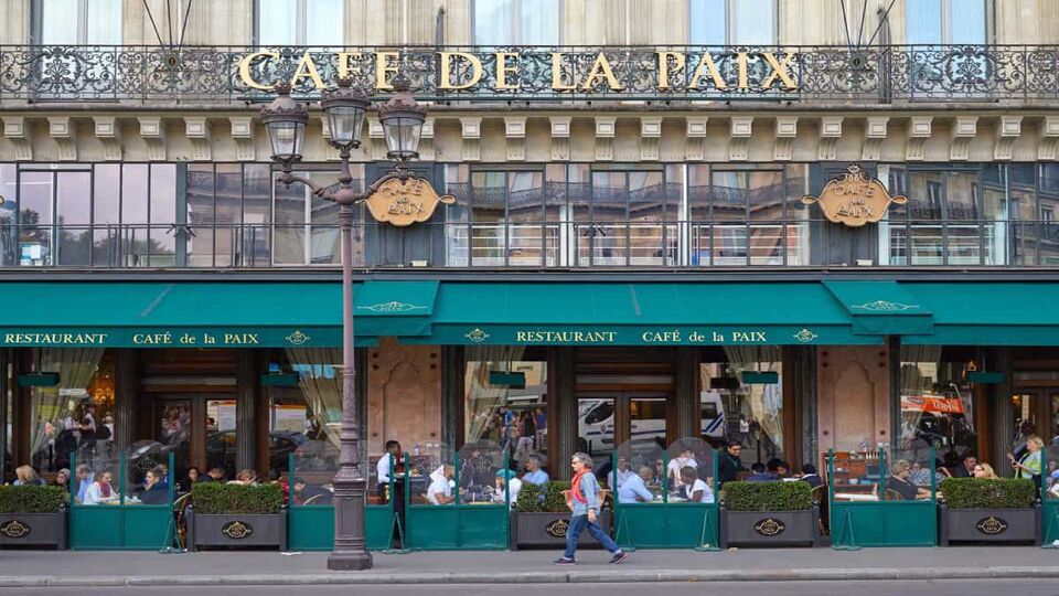 Famous Cafe de la Paix with people and tourists sitting outdoor in Paris