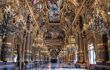 The Grand Foyer in Palais Garnier, where there are large black and gold podiums lined across the perimeter of the hall.