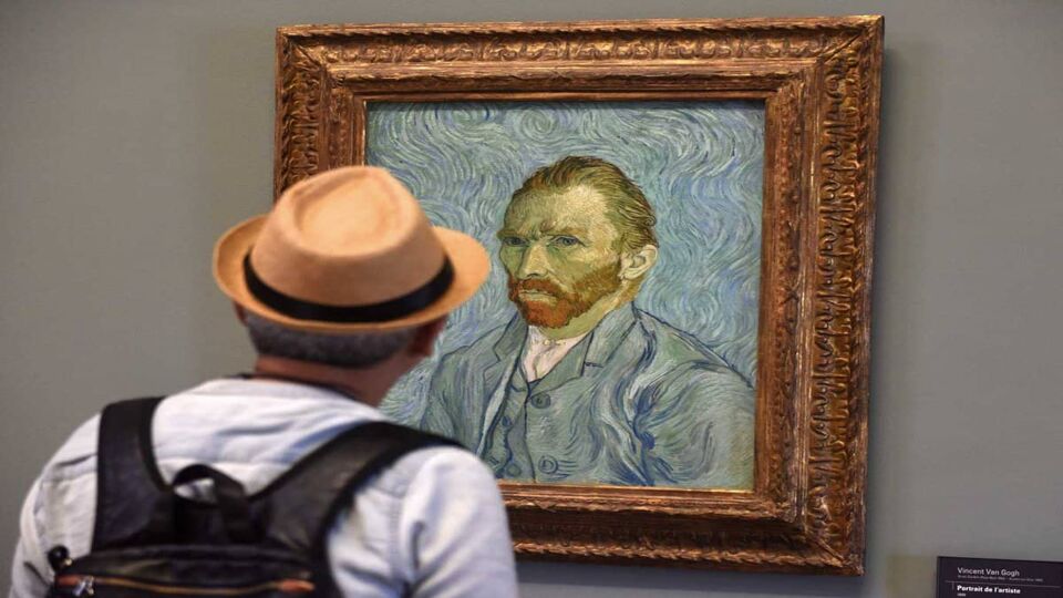 Man looking at Van Gogh's self-portrait in the Orsay Museum
