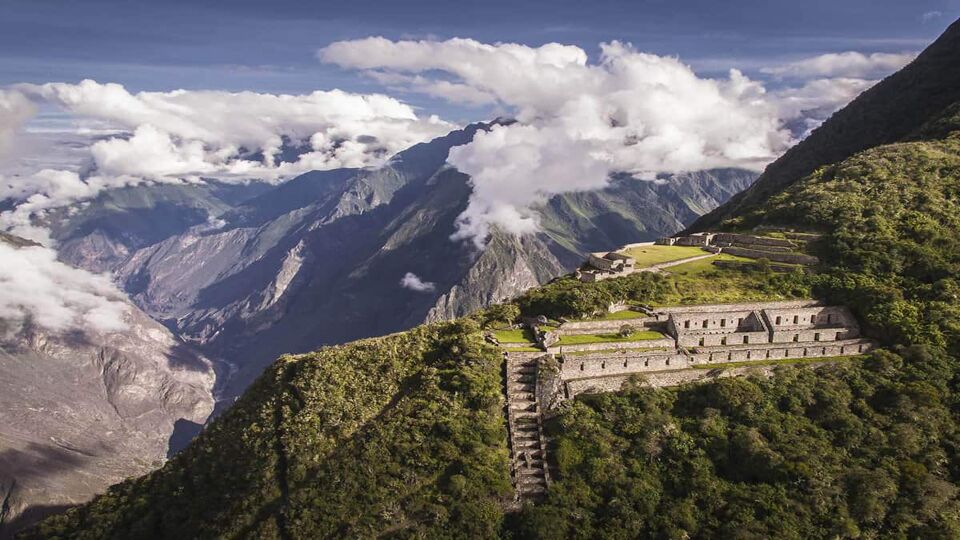 Incan ruins, buildings and terraces on a cloudy truncated hill top