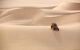 A sand buggy descends a sand dune