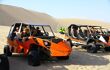Three sand buggies filled with tourists parked next to each other