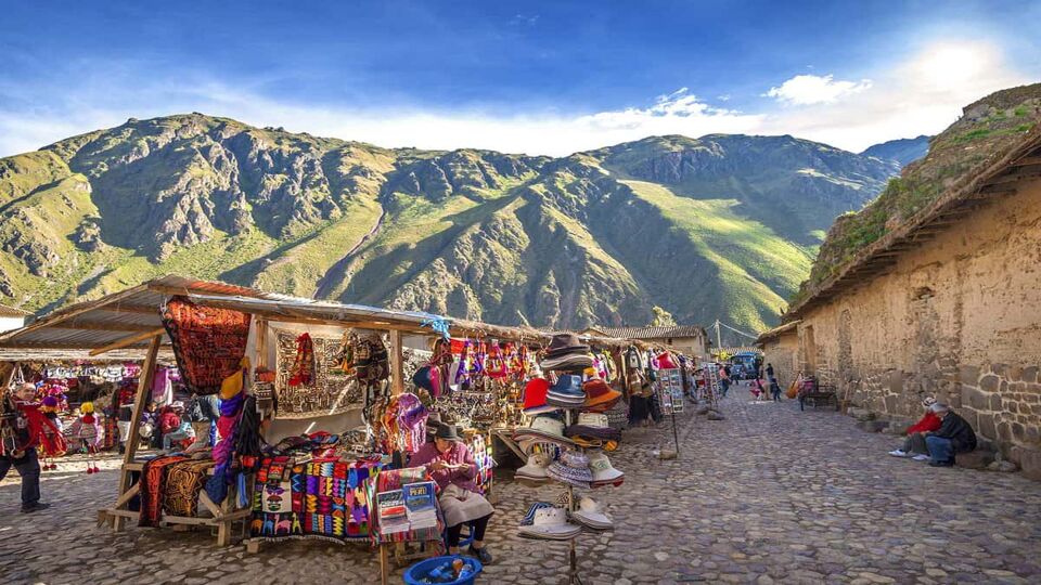 Stalls selling souvenirs lined up, with mountains in the background