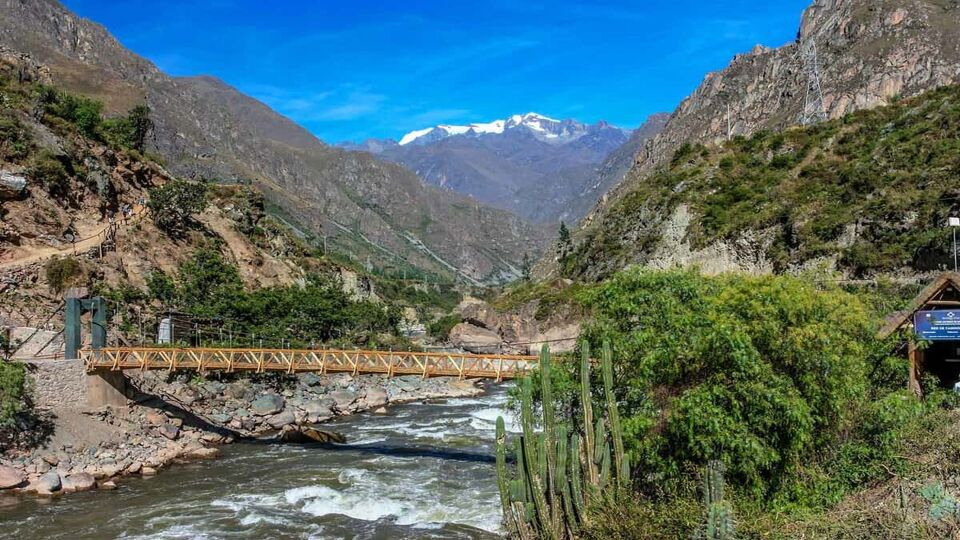 A bridge crossing a wide river in a mountainous region