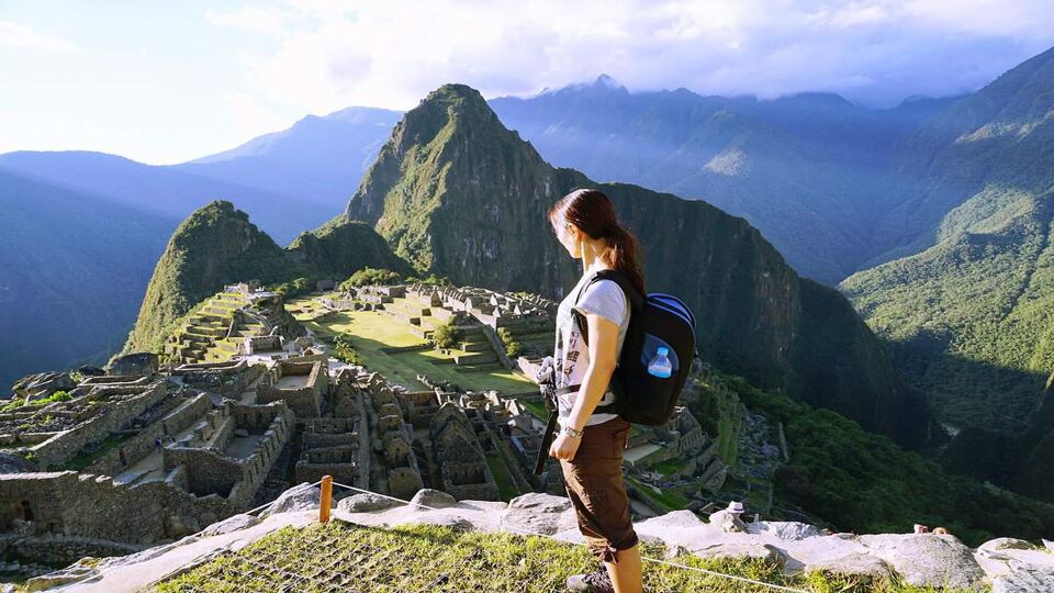 A traveller looks over a mountainous view on the trail