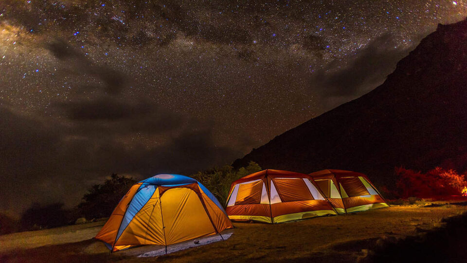 Tents lit up under a starry sky