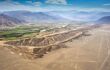 A desert region, with a small and mountains in the background