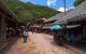 A dirt road with thatched roof restaurants on either side