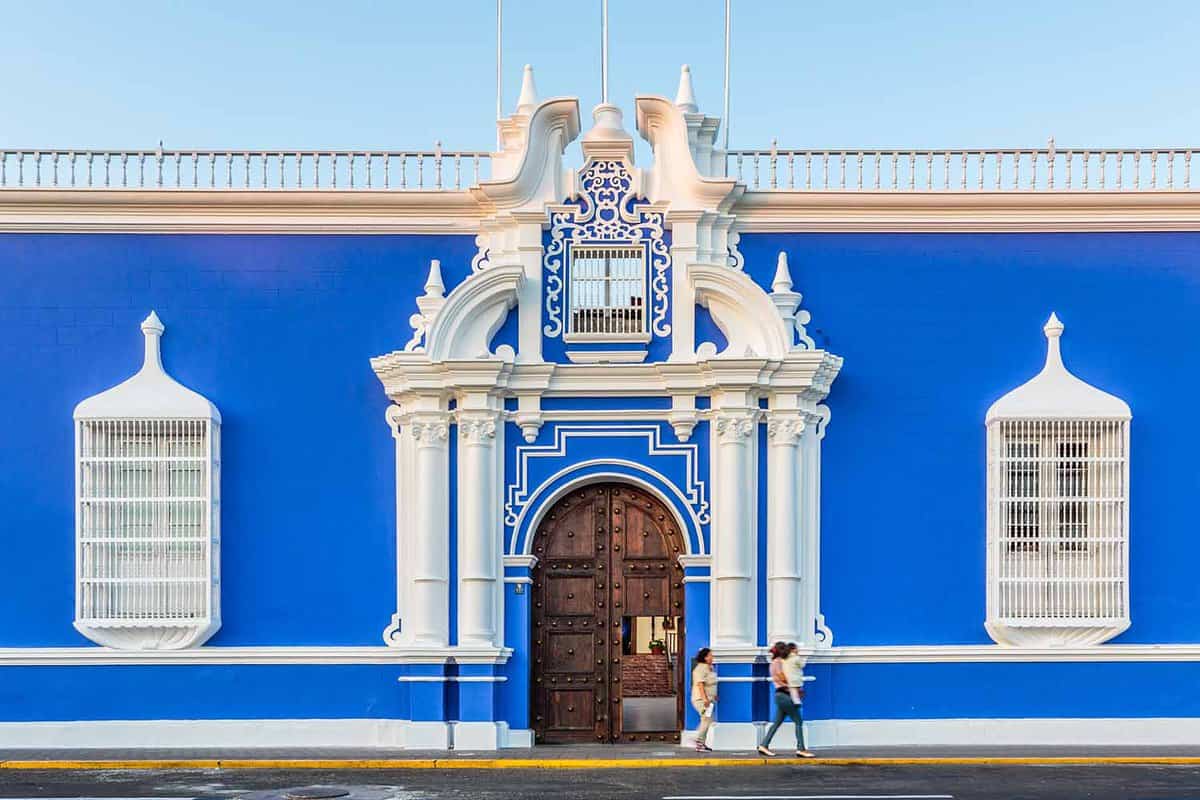 Antique blue painted building with white fixtures in Trujillo