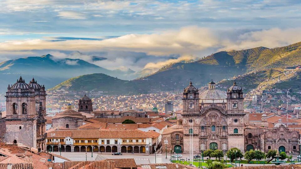View over the city of Cusco, with misty mountains in the background