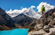 A traveller looks over a bright turquoise lake and mountains