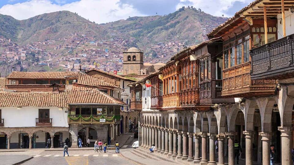 A main street in Cusco, with mountains in the background