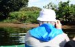 Tourist on a boat cruise taking a photo of a crocodile in the background