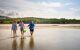 Aboriginal guide with two guests on the beach explaining fishing methods on the beach