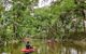 Two people on red floats drifting down the Mossman River