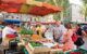 People standing at a food stall in the market